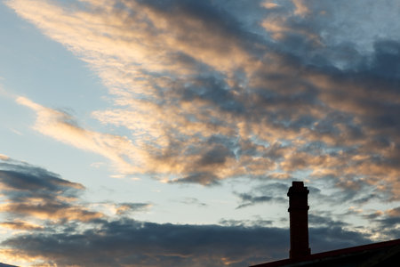 Chimney silhouette against the sunset sky. Chimney on the roof of the house.の写真素材