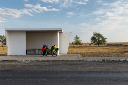 tourist bike stands at a bus stop in Kazakhstan. Bicycle with heavy bags. Cycling around the world.