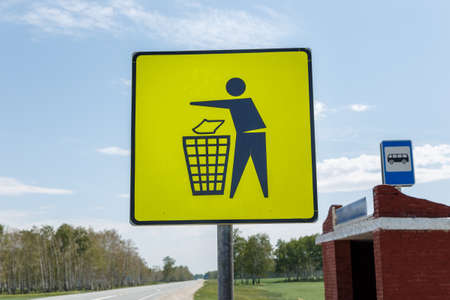 Garbage disposal. Yellow trash can sign at the bus stop. Trash icon sign on yellow label, road signsの写真素材