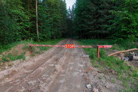 Stop sign in the forest. Road closed barrier in the forest.