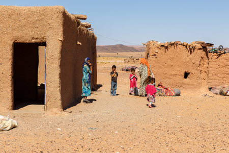 Errachidia Province, Morocco - October 15, 2015: Berber huts in the Sahara Desert. Berber women and children stand outside the house.のeditorial素材