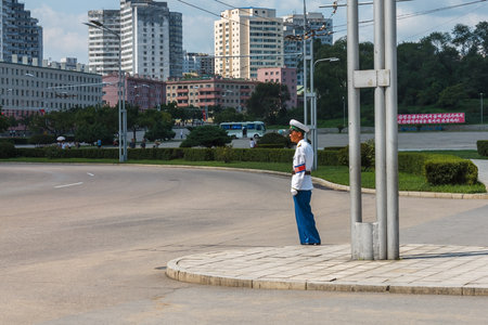 Pyongyang, North Korea - July 27, 2014: A police officer regulates traffic at an intersection in...