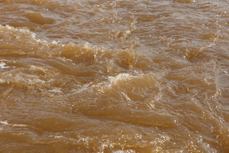 Muddy river water. Spring river with brown muddy water. Background
