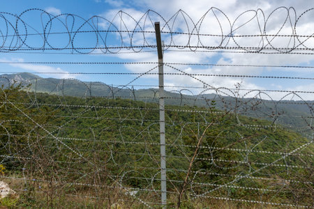 Barbed wire fencing outlines the border between Iran and Azerbaijan amid a mountainous landscape...