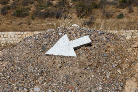 A white arrow marker is positioned on a gravel mound along the Gorgan Bojnord road in Iran, directing travelers to their destination.の写真素材