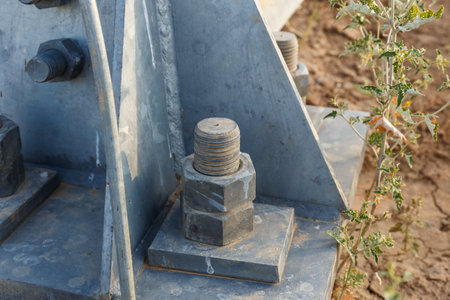 Close up view of a bolt securing an electric transmission line support in a dry landscape. Detailed focus on the construction materials used.の写真素材