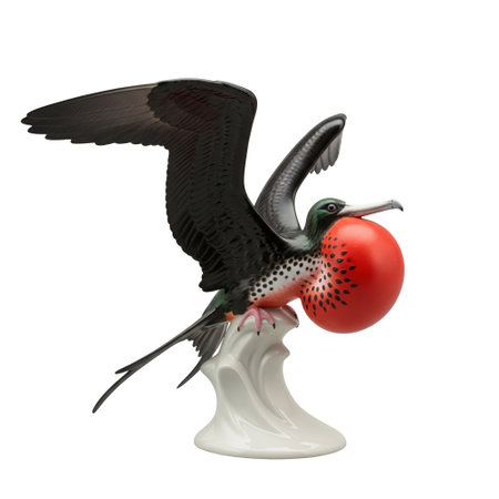 Vintage porcelain figurine of a frigatebird with spread wings and a red gular sac. A collectible tropical wildlife souvenir.の素材