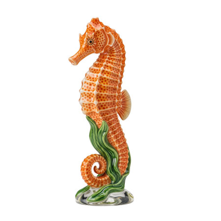 A vibrant orange porcelain seahorse figurine with detailed spots and a glossy finish. It is intertwined with green seaweed.の素材