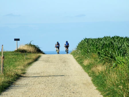 Two cyclists riding a bike on a summer dayの写真素材