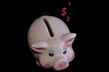 Pink piggy bank isolated over black backgroundの写真素材