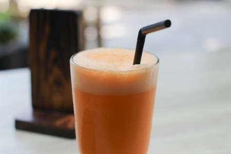 Iced carrot juice on the table in coffee shop, stock photoの写真素材