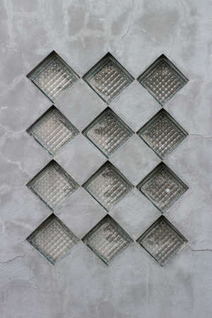 A vertical shot of a glass window on a concrete wall with tilesの写真素材