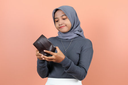 beautiful Asian woman holding a wallet and opening it with both hands and a frowning face