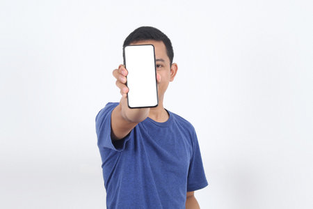 Handsome young Asian man showing a screen mobile phone with blank screen for an advertisement and celebrating success. People Lifestyle Conceptの写真素材