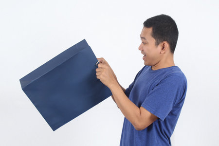 shocked Asian man holding empty shopping bag with surprised emotion, isolated over white background