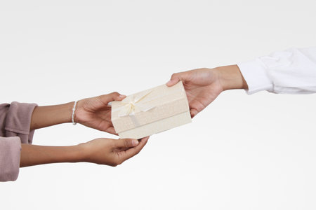 giving with one hand a pastel colored gift with a white ribbon and the other hand receiving it with...