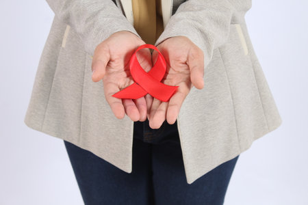 Red Ribbon Holds Symbol of Support and Solidarity for Important Cause Awareness Campaign AIDS and...