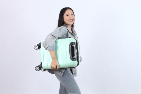 Woman Carries Luggage Joyfully and Enthusiastically Prepares for Vacation with Suitcase, Travel Bag, and Journey Excitement.の写真素材