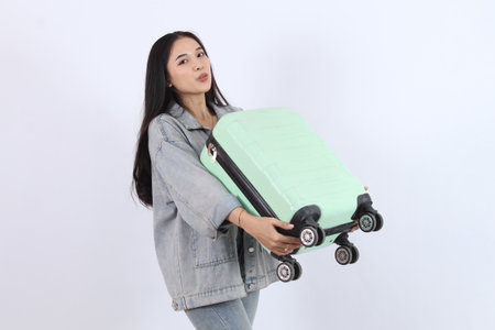 Woman Holds Luggage, Ready for Travel Adventure Excitement Enthusiasticallyの写真素材