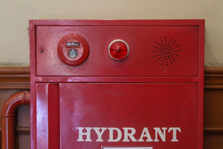 Close up of a red indoor fire hydrant cabinet with a push-button alarm. Concept for safety, protection, and emergency preparedness.の写真素材