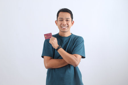 Portrait of a satisfied male customer showing his credit card for easy online shopping and contactless payment.の写真素材