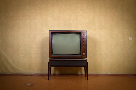 Retro TV on a background of vintage wallpaper in old room with vignettingの写真素材