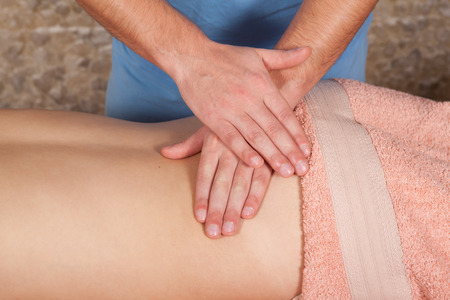 Masseur doing massage a young girl on a massage table