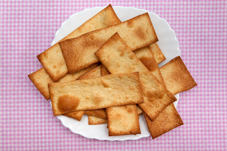 Biscuits arranged on a plate on a red tablecloth in a cageの写真素材