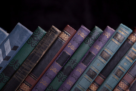 Decrepit old vintage book compiled in a row on a black background