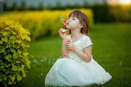Little girl playing in the park with a bubbleの写真素材