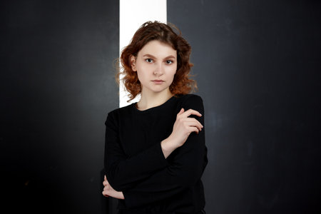 Portrait of a young attractive girl in black clothes on a dark background. Close-up.の写真素材