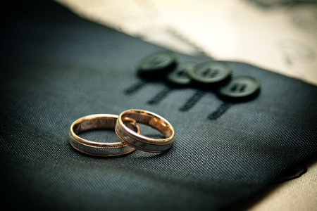 Wedding rings on the sleeve of his jacketの写真素材