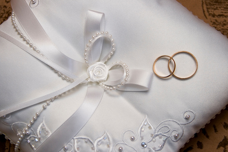 Gold rings on a silk cushionの写真素材