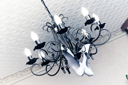 Bride shoes hung on a chandelierの写真素材