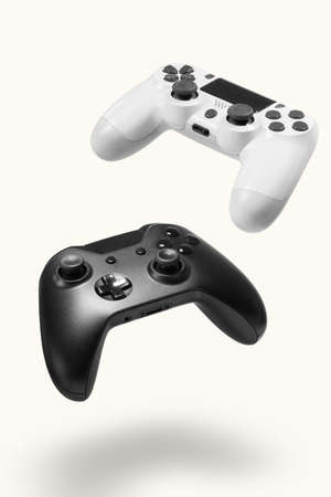 White and black game controllers on white background