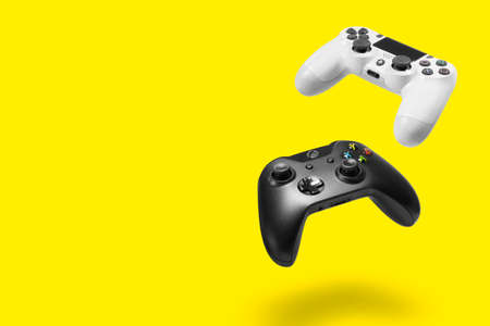 Playstation 4 and Xbox One controllers on yellow background, Sao Paulo, Brazil - 03/10/2020のeditorial素材