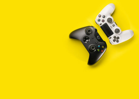 Sao Paulo, Brazil - 02/09/2020: Xbox One and Playstation 4 controllers on yellow background