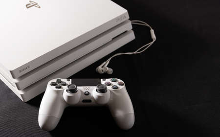 White game console with control and handset on black background