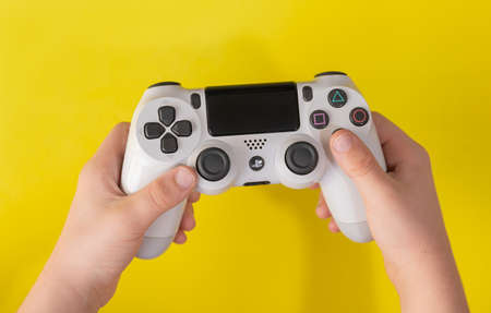 Child hand holding Playstation 4 white controller, Sao Paulo, Brazil, 27/09/2020のeditorial素材