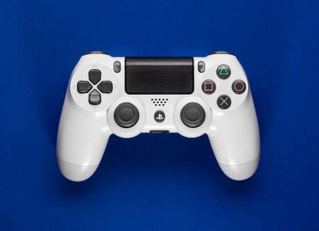 White Playstation 4 controller on blue background. Sao Paulo, Brazil, 09/04/2020.のeditorial素材