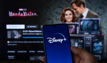 Disney plus running on smartphone screen with WandaVision on TV in background. Feb 17, 2021, Sao...