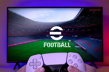 Kid hold playstation 5 controller with e-football game running on TV. 26th Jul, 2021, Sao Paulo, Brazilのeditorial素材