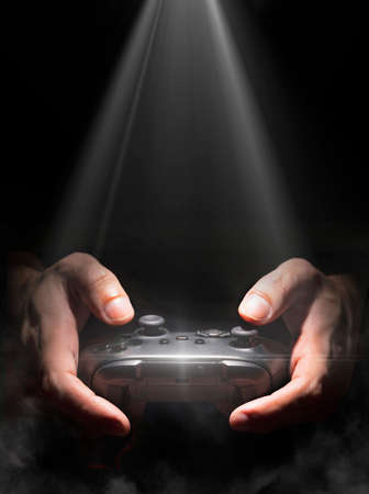 Man holding game controller with spot light and fogの写真素材