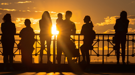 group of happy young people look on beautiful summer sunsetの写真素材