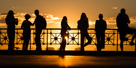 group of happy young people look on beautiful summer sunsetの写真素材