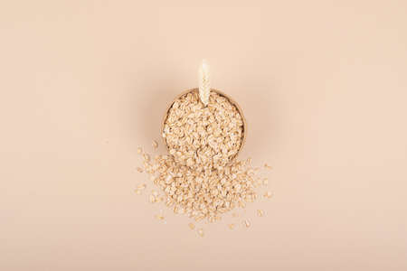 A wooden bowl filled with natural oats in a minimalist style. top viewの写真素材