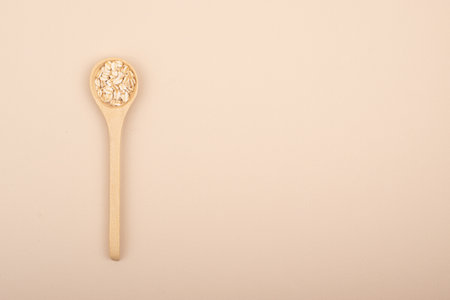 A minimalistic wooden spoon with natural oats.Top viewの写真素材