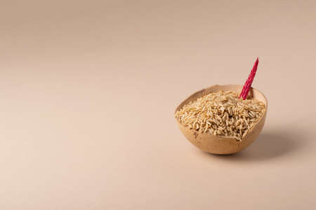A wooden bowl filled with whole grain rice in a minimalist style. front viewの写真素材