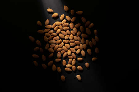 Scattered almonds are illuminated with a soft point light with an overhead view.の写真素材