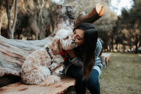 <p>Girl kissing her dog in the park. The girl loves her dog.</p>の写真素材